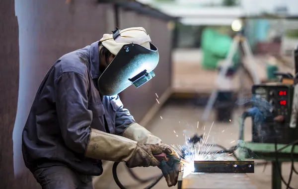 Soldador latino trabajando en estructura